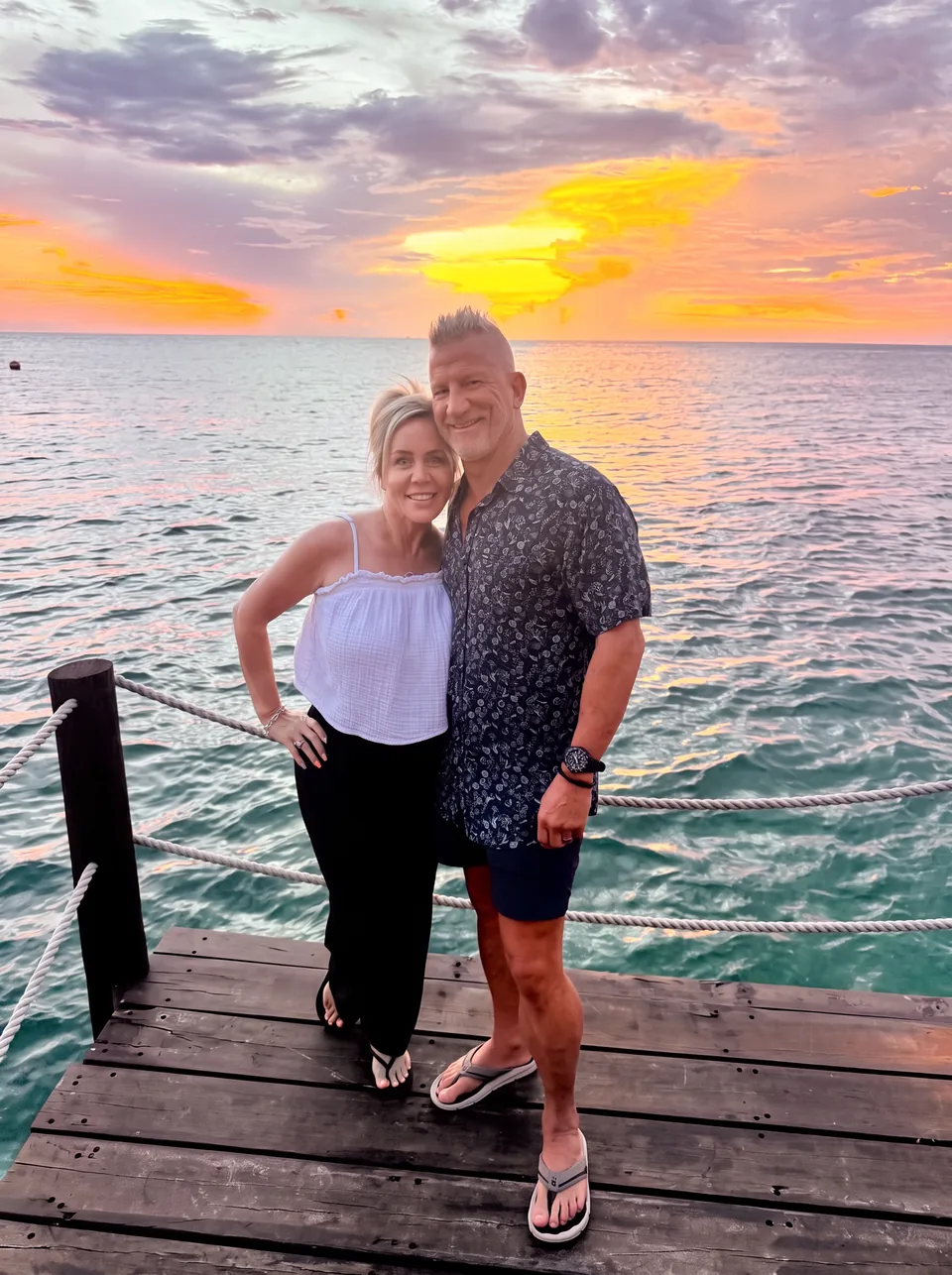 James and Stacy Parsons standing on a dock at sunset over the Caribbean in Cozumel